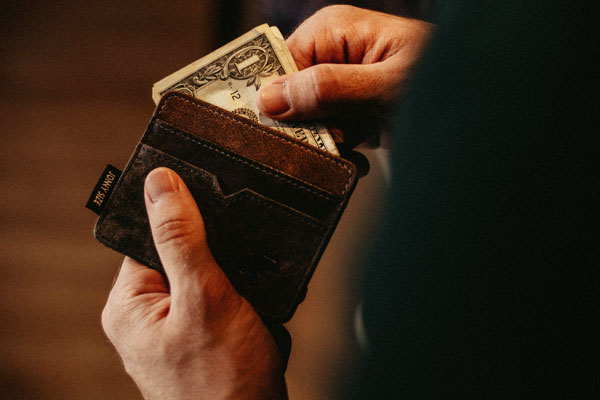 photo of a man getting one dollar from his wallet